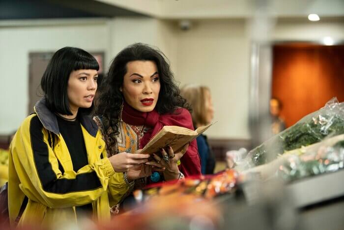 Two women holding a weathered book. SBS program Hungry Ghosts (2020).